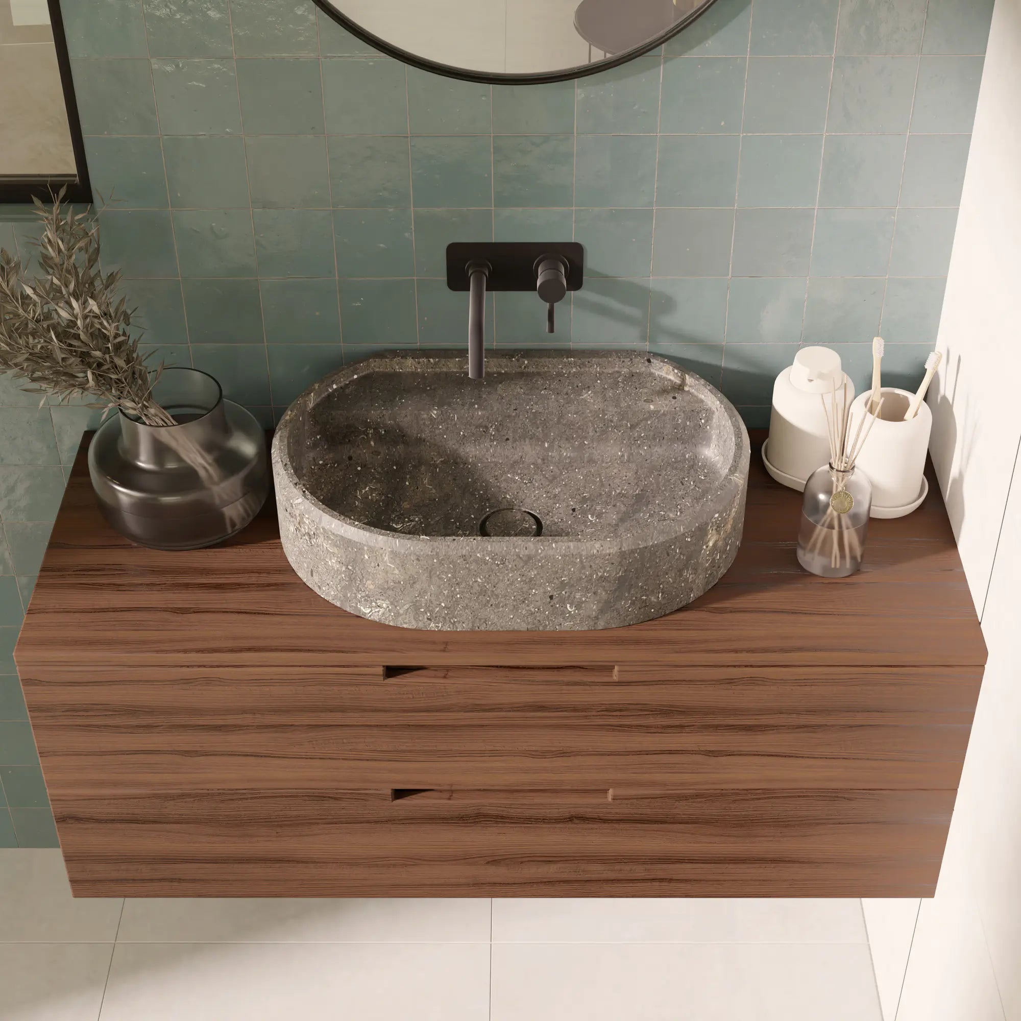 Vasque à poser ovale design en pierre naturelle bleu gris San Vicente, bonde Magique en pierre, robinetterie murale noire, meuble suspendu en bois foncé, miroir rond noir, mur en zellige vert d'eau, salle de bain contemporaine