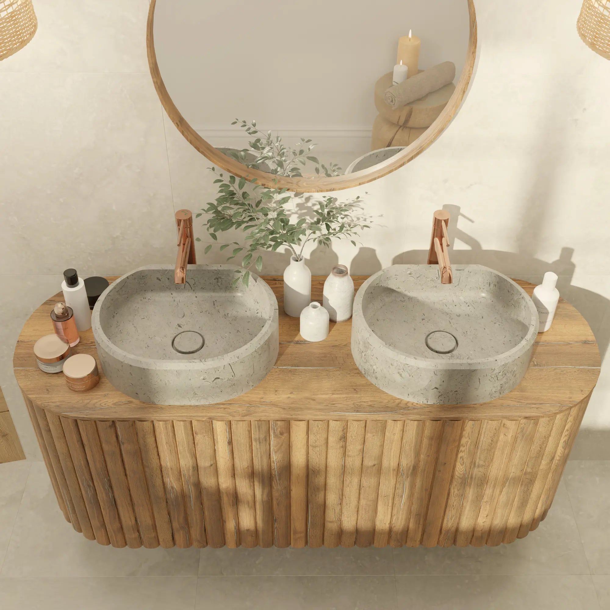 Double vasque à poser ovale en pierre naturelle Gris des Alpes, posée sur un meuble en bois cannelé arrondi, robinetterie cuivre, grand miroir rond, salle de bain nature