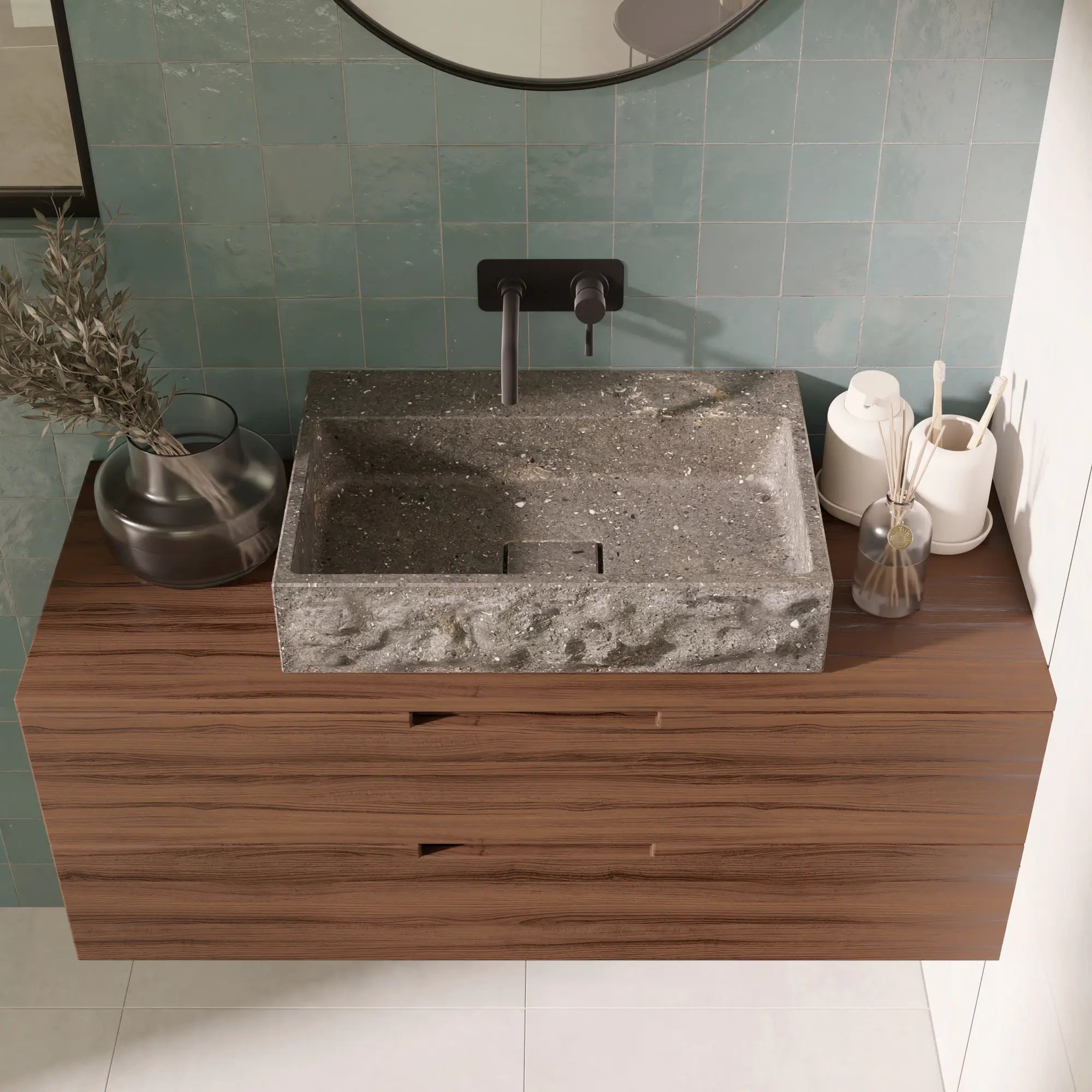  Vasque à poser rectangulaire minimaliste design en pierre naturelle bleu gris San Vicente, contour brut et cuve polie, bonde Magique rectangulaire en pierre, robinetterie murale noire, meuble suspendu en bois foncé, miroir rond noir, mur en zellige vert d'eau, salle de bain contemporaine