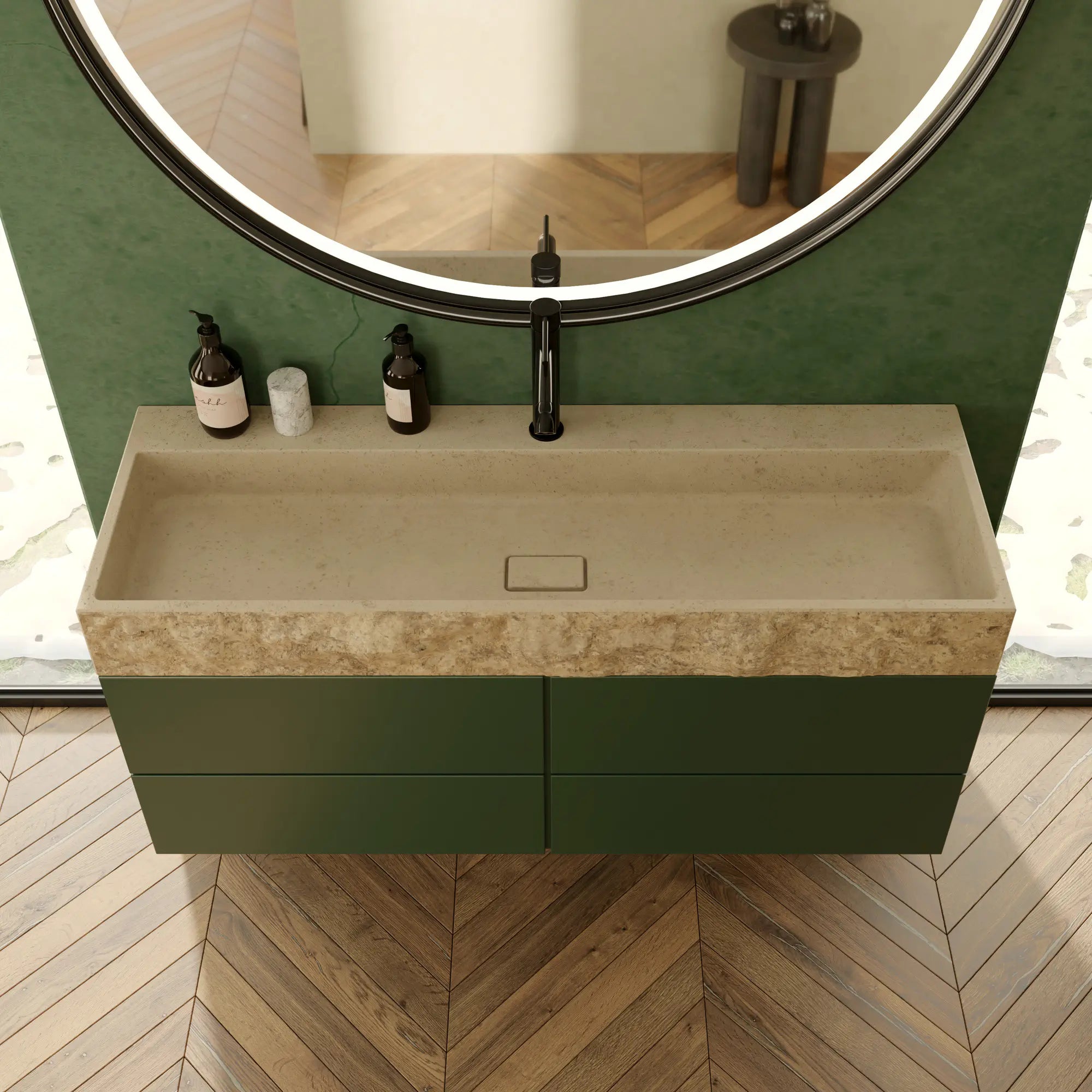 Plan de vasque rectangulaire minimaliste en pierre naturelle crème Moléanos, contour brut et cuve polie, bonde Magique rectangulaire en pierre, meuble suspendu vert, robinetterie noire, miroir rond LED, mur vert et parquet chevron, salle de bain contemporaine